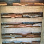 Underside of the roof tiles. Watching the tilemaker I had wondered about the tabs at one end of an otherwise smooth tile. This view made clear why they were there - they hooked onto wooden crossbars and that was what kept them in place!